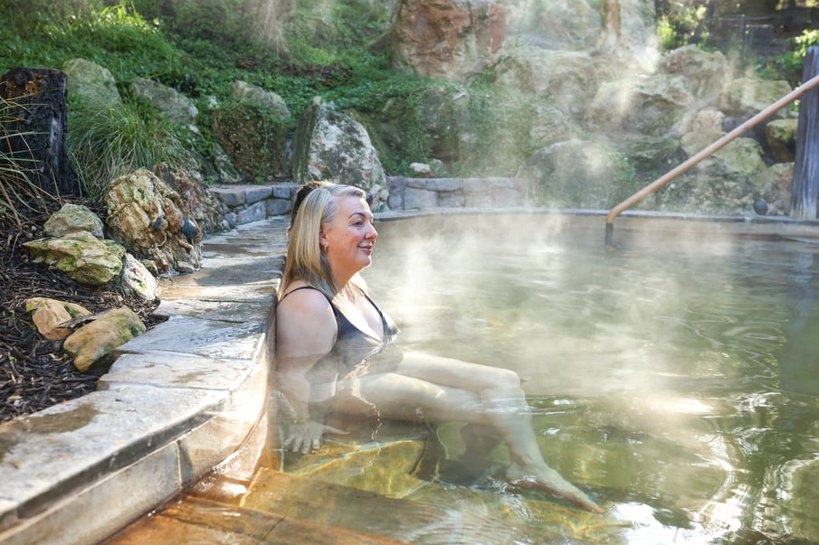 Two women bathing is steaming hot springs