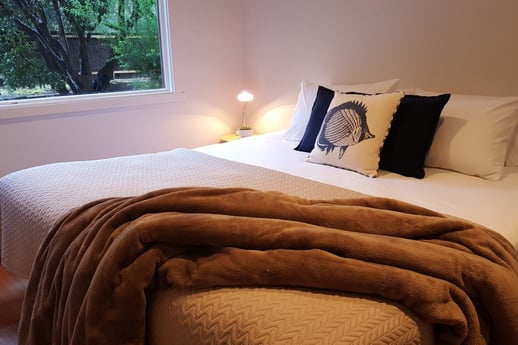 A bed with a copper throw rug