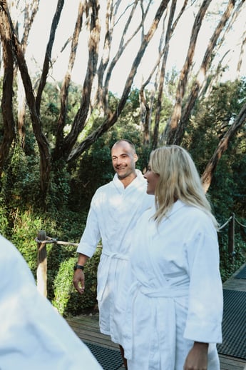 A man and woman walking in a white robe