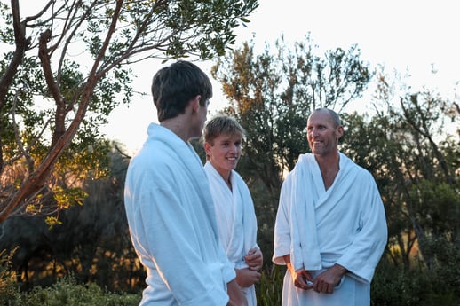 A father and two sons wandering the grounds in white robes